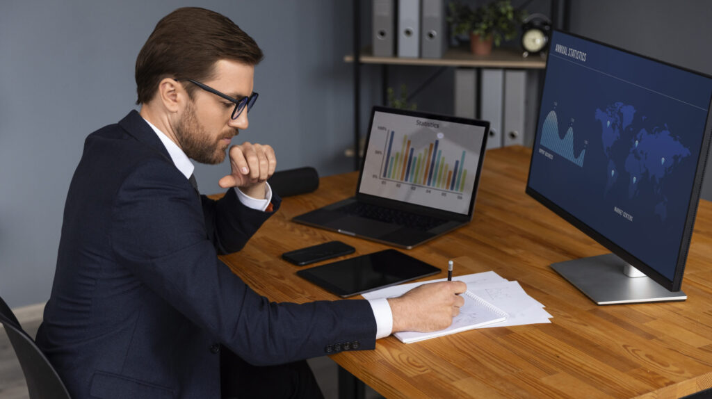 Business manager analyzing ERP-generated inventory and stock level reports on laptop