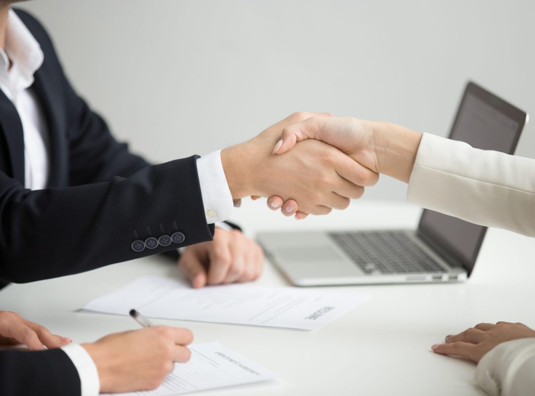 Hr handshaking successful candidate getting hired at new job, cl Employment handshake concept, female hr and successful woman candidate shaking hands getting hired ready to sign job contract concept, employer congratulating welcoming new worker, close up view